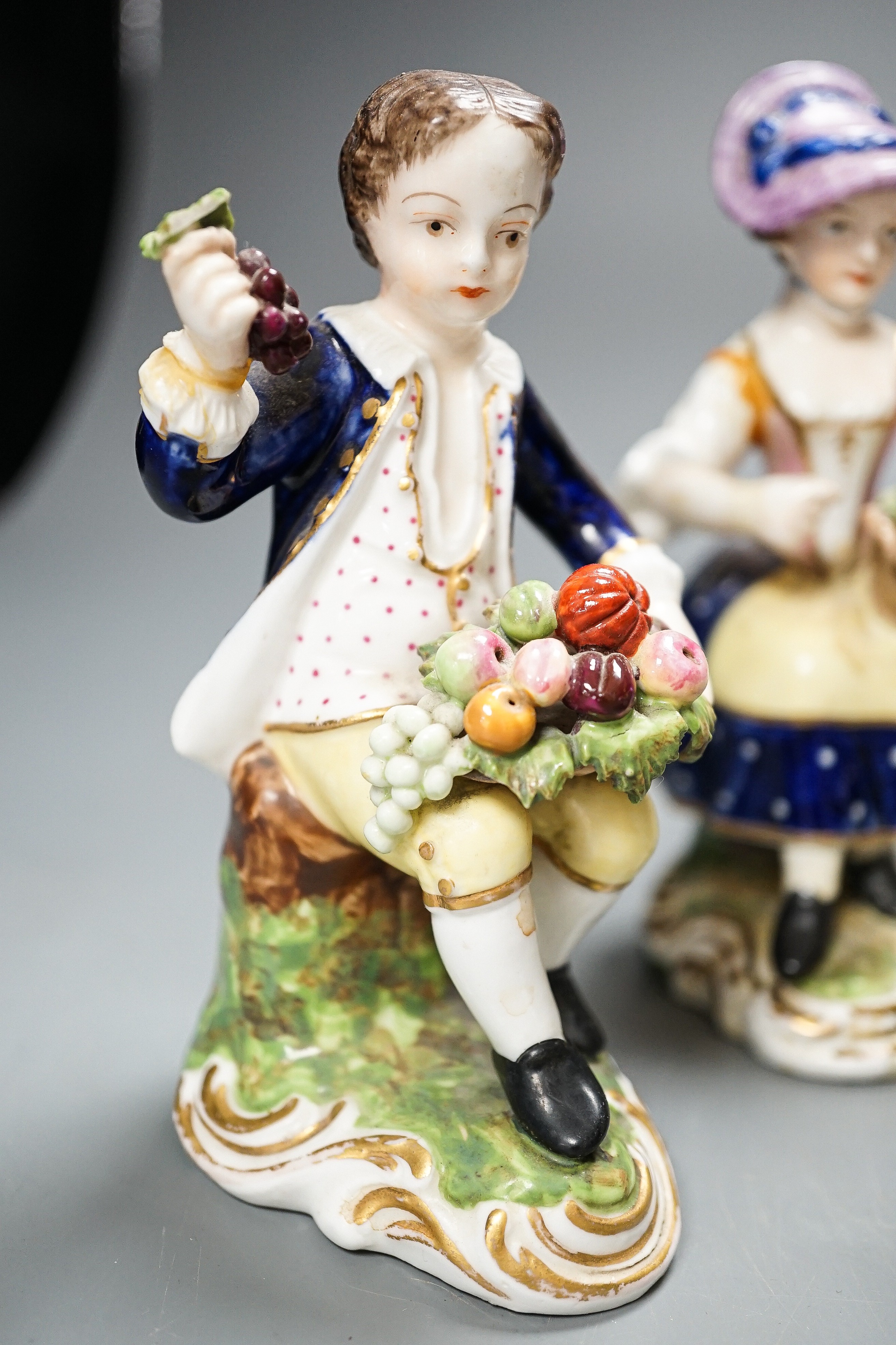 A Derby Imari saucer, a similar tea cup, a pair of Sampson Hancock, Derby figures, and a Derby cup, tallest figure 13 cms high.